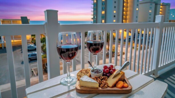 A balcony with a view of buildings and a sunset. - Spacious 2 Bedroom/2 bathroom Condo with Ocean View, Pool, Elevator, and Balcony (North Myrtle Beach)