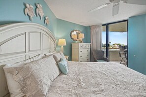 Un dormitorio con cama, cómoda, silla y un balcón con vistas.
