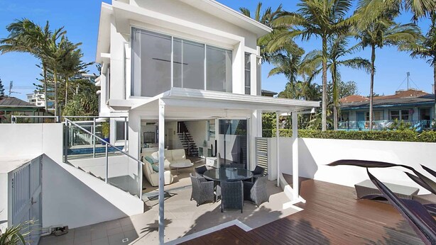 A modern two-story house with a glass-enclosed patio, a pool, and a staircase leading to the upper level. - Rainbow Bay Villa - Spacious and Luxurious (Coolangatta)