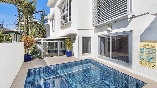 Un bâtiment moderne doté d’une piscine, de grandes fenêtres et d’un panneau d’information sur la réanimation cardio-pulmonaire (RCP).