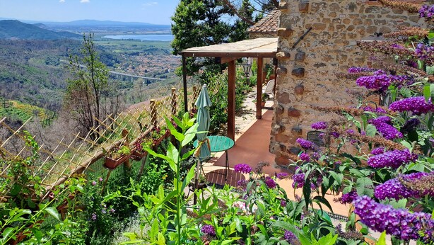 A stone building with a garden, a pergola, and a view of a valley. - Cozy stone house in the green, sea-lake view, garden, air cond. WIFI, washer (Montigiano)