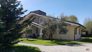 Ein zweistöckiges Haus mit einer Stein-Fassade, einem Ziegeldach und einer gepflasterten Auffahrt.