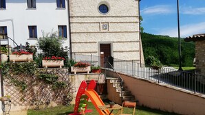 A building with a stone facade, a small window, and a door. - Ancient Plan. Appart in the Greenest Umbria: Nature, History, Genuineness, Relax (Nocera Umbra (PG))