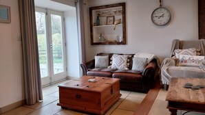 Ein gemütliches Wohnzimmer mit einer Holzkiste, einem braunen Ledersofa und einem Couchtisch aus Holz.