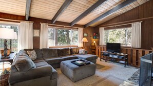 A cozy living room with a sectional sofa, a coffee table, a TV, and a fireplace. - (24B) Bird's Eye View at The Redwoods In Yosemite (Yosemite National Park)