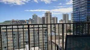 A high-rise building with multiple balconies and a clear sky.