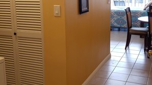 A hallway with a closed door, a framed picture, and a patterned rug.