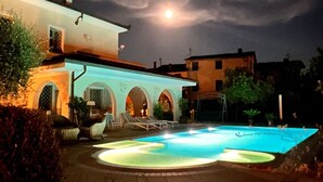 A swimming pool with a moon in the background. - Ground floor villa apartment with garden and pool, 1 km from the city (Lucca)