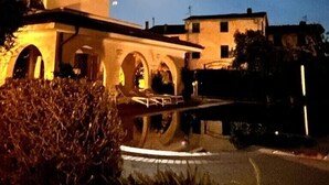 A building with a courtyard and arches, under a night sky with a visible moon. - Ground floor villa apartment with garden and pool, 1 km from the city (Lucca)