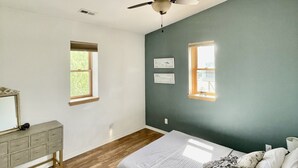 A bedroom with a bed, a dresser, a ceiling fan, and two windows. - Beautiful Apartment With Great Views In The Colorado Countryside. (Durango)