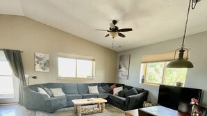 A spacious living room with a sectional sofa, a coffee table, and a dining area with a table and chairs. - Beautiful Apartment With Great Views In The Colorado Countryside. (Durango)