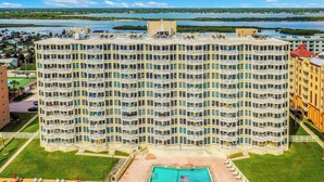 Un hôtel à plusieurs étages doté d’une cour intérieure avec une piscine et un espace salon extérieur.