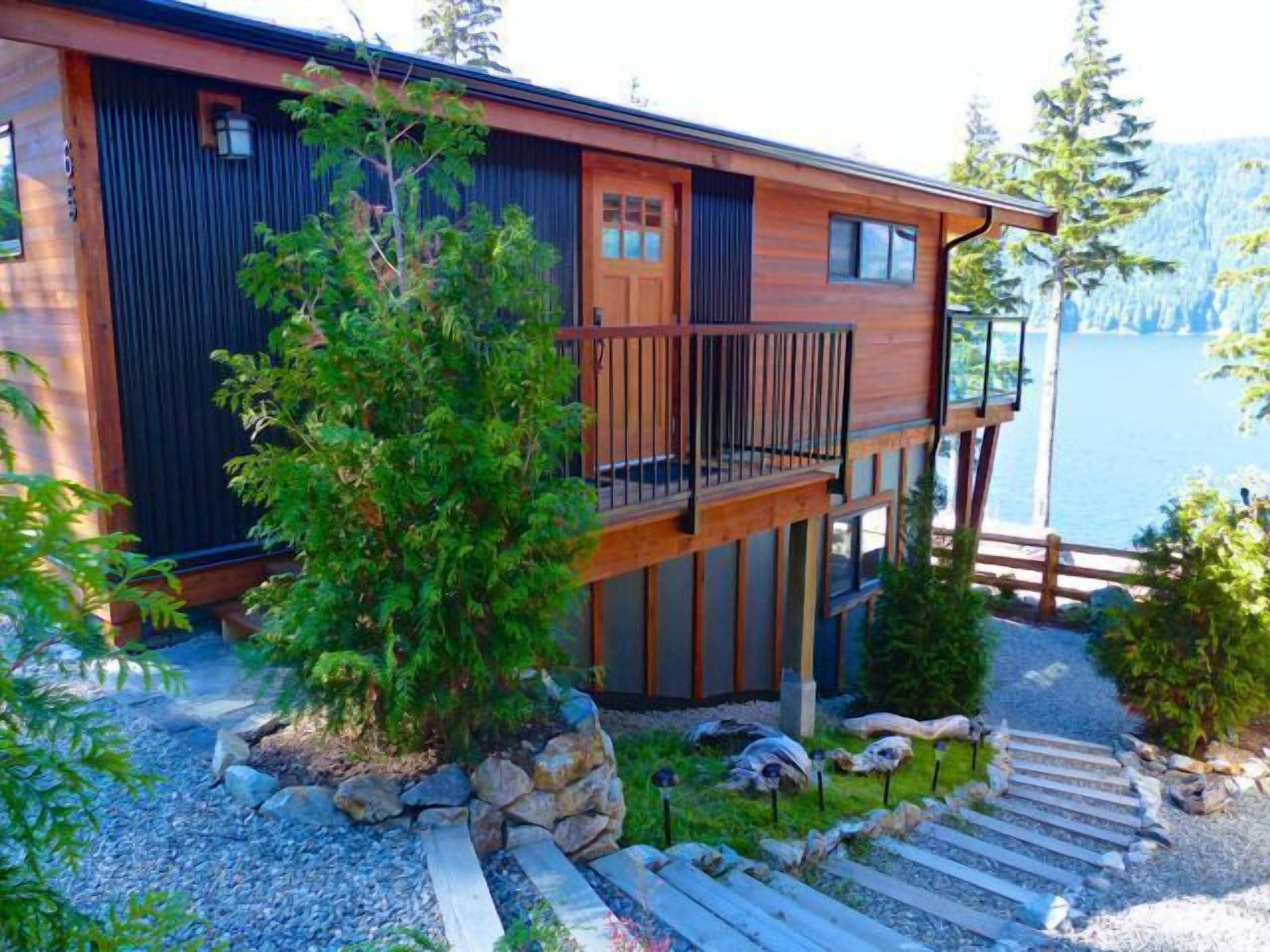 A two-story cabin with a wooden deck and a front door.