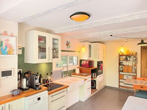A kitchen with white cabinets, a wooden countertop, a built-in oven, a microwave, and a window. - HOUSE OF 3 BEDROOMS 10 MIN WALK FROM THE CENTER OF SAINT REMY DE PROVENCE (Saint-Rémy-de-Provence)