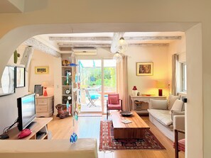 Uma sala de estar acolhedora com televisão, mesa de centro e área de estar.