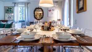 A dining table set for six with clear glassware, white plates, and silverware. A candle centerpiece and a mirror are on the wall. - VILLA SIENA is 4 km from Siena 10PAX AC, POOL & SPA total privacy. (Siena)