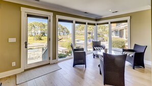 Une pièce spacieuse dotée de grandes portes-fenêtres coulissantes qui donnent sur un patio extérieur.