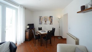 Ein Essbereich mit Tisch, Stühlen, einem Fernseher und Kunstwerken an der Wand.