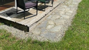 Un bâtiment écologique doté d’un patio comprenant deux chaises noires et une table.