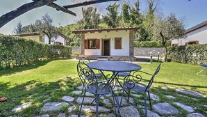 A patio with a round table and chairs, surrounded by stone steps and greenery. - Villino Alfredo A: A charming cottage situated in a quiet location, a few minutes from the town center, with Free WI-FI. (Massa Lubrense)