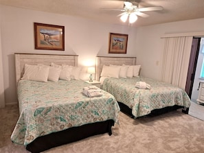 A hotel room with two beds, a ceiling fan, and two framed pictures on the walls. - Relaxation #201 Free Beach Service Included Chateau La Mer II 1st Fl (Destin)