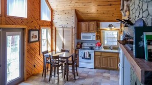 Una cucina accogliente con mobili in legno, un tavolo da pranzo e una parete decorata con pietra.