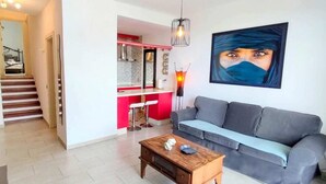 A living room with a grey sofa, a wooden coffee table, and a painting on the wall.