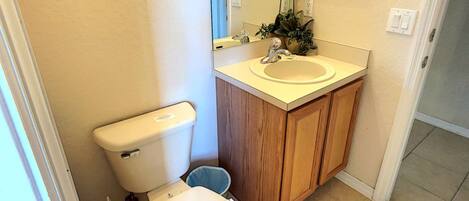 A small bathroom with a toilet, sink, and mirror.