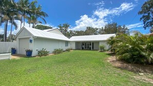 A single-story house with a white exterior, a covered porch, and a well-maintained lawn. - Riverside - Burrum Heads- Riverfront - 3BR - River Fishing... (BURRUM HEADS)