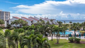 Un resort con piscina, palmeras y vista al océano.