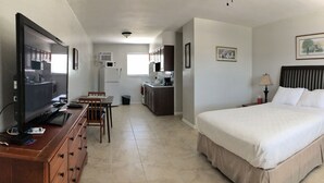 Una habitación de hotel con cama, televisión, escritorio y silla.