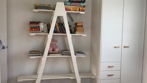 A white bookshelf with multiple shelves, some books, and a teddy bear. - 9 Indigo Avenue - Rainbow Beach. Close to beach and main street. Walk to everything (RAINBOW BEACH)