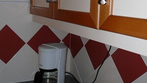 A kitchen with wooden cabinets, a coffee maker, and a tiled backsplash. - Reberty les Menuires very beautiful 2 rooms facing south (saint martin de belleville)