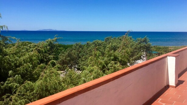 Ein Balkon mit Blick auf das Meer und das entfernte Land.