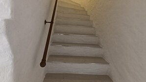 Eine Treppe mit weißen Wänden und einem hölzernen Geländer.