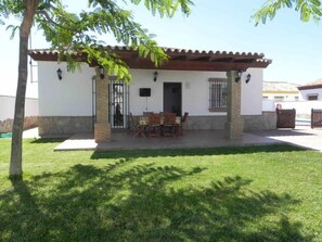 A house with a patio, a dining table, and chairs. - Large pool area, 4 bikes, free Wi-Fi, 2 parking spaces - Casa Anita - (Conil de la Frontera)