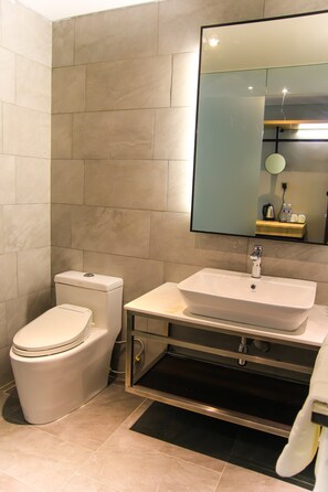 Un baño con inodoro, lavabo y espejo.