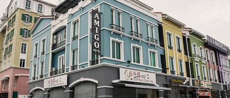 A multi-story building with a sign reading "AMIGO HOTEL" on the facade.