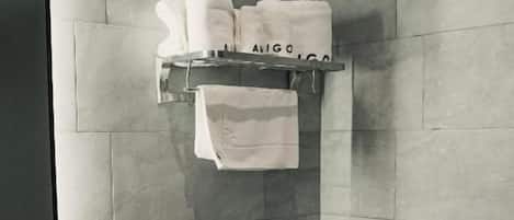 A modern bathroom with a toilet, sink, and towel rack.