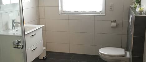 Een douche, een haardroger, zeep, toiletpapier