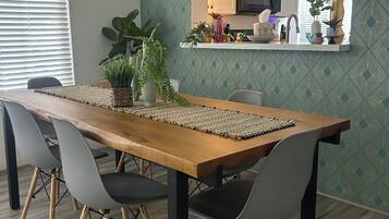 A dining area with a wooden table, grey chairs, and a woven placemat.
