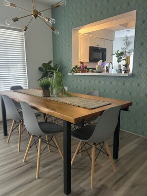 A dining area with a wooden table, grey chairs, and a woven placemat.