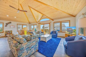 A spacious living room with a high ceiling, large windows, and a view of the outside. - Semi-Oceanfront Dog Friendly w/ Hot Tub, Game Room, Community Pool and Tennis (Avon)