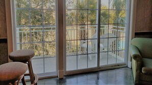 A room with a sliding glass door leading to an outdoor patio with chairs and a table.