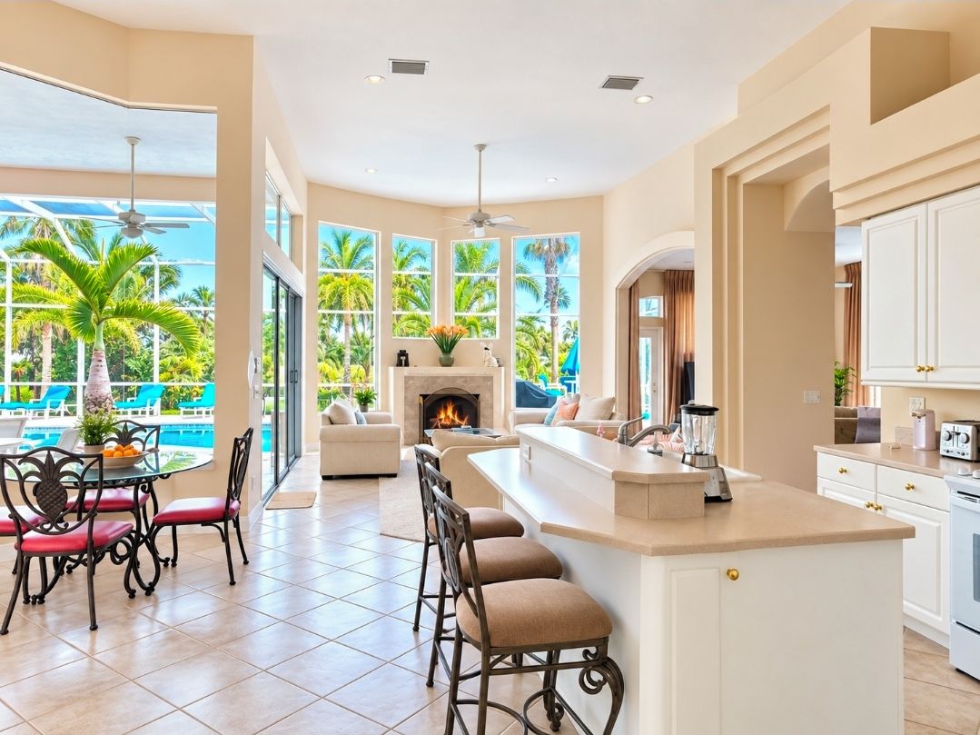 Soaring 18-foot windows fill the spacious living room & Kitchen  with natural light and beautiful pool and tropical views.”