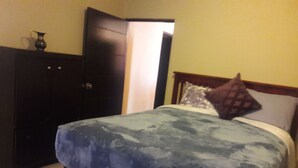 Una camera da letto con un letto, un armadio e una porta.