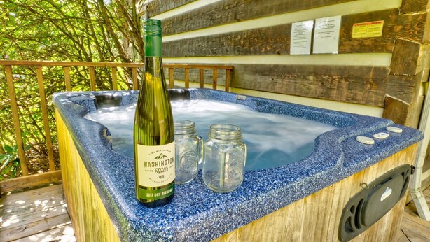 A hot tub with a bottle of wine and mason jars. - Hearts Bursting with Love  Romantic Creekside Retreat!! (Cosby)