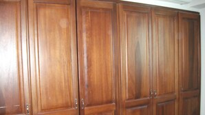 Une grande armoire en bois, dotée de plusieurs portes et de nombreux tiroirs.