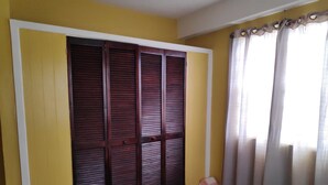 Une chambre à coucher avec un lit, une armoire et des rideaux.