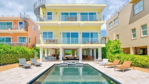 A multi-story building with a swimming pool, outdoor seating, and balconies.